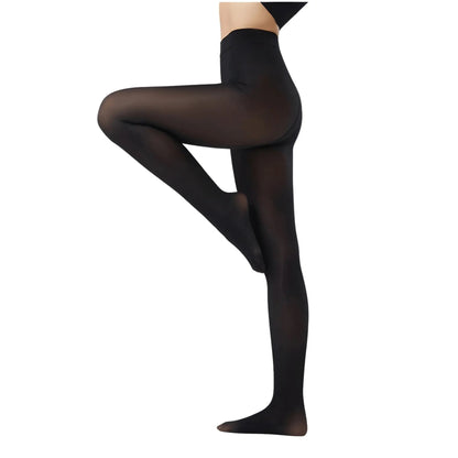 A three-quarter shot of a female model sitting on the floor, wearing nude or light beige ultra-sheer slimming tights and a light cream-colored athletic crop top. The control-top waistband is visible.